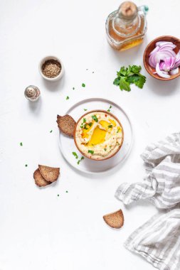 Nohut humusu, kızarmış ekmek, zeytin yağı ve beyaz arka planda kırmızı biber.