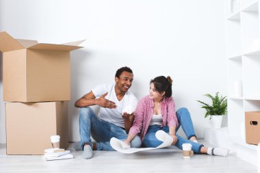 Mutlu çift, yeni ev katta oturan dekorasyon planlama.