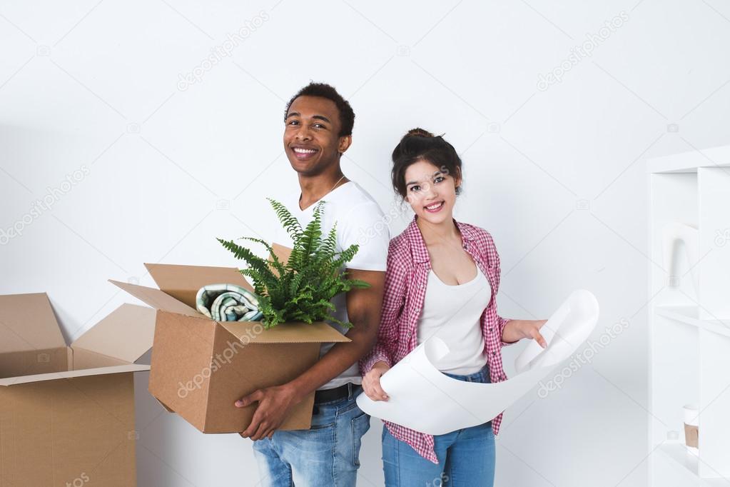 Portrait of happy young multiracial couple in the new home.