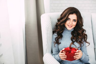 Kırmızı kalp kameraya bakarak mevcut olan kadın. 