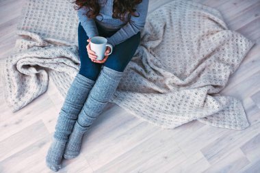 Elinde kahve olan bir kadın..