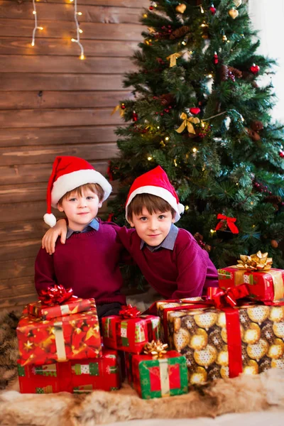 Bambini sotto l'albero di Natale con scatole regalo . — Foto Stock