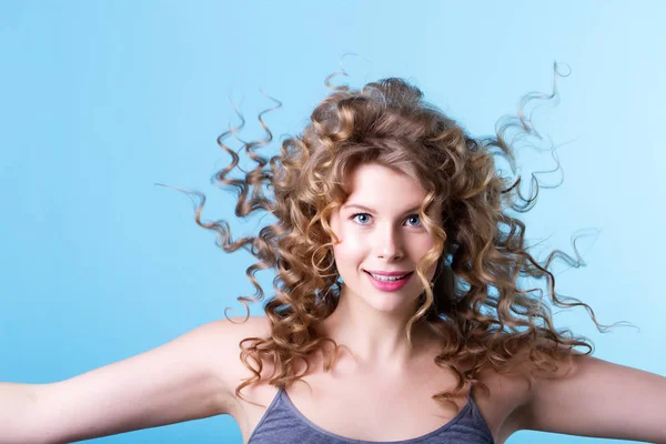 Beautiful woman with curly hair in wind. — Stock Photo, Image