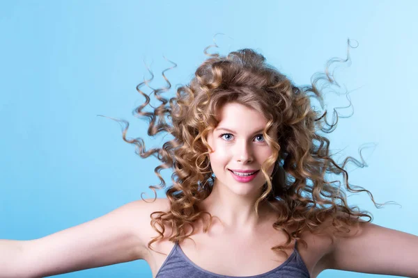 Schöne Frau mit lockigem Haar im Wind. — Stockfoto