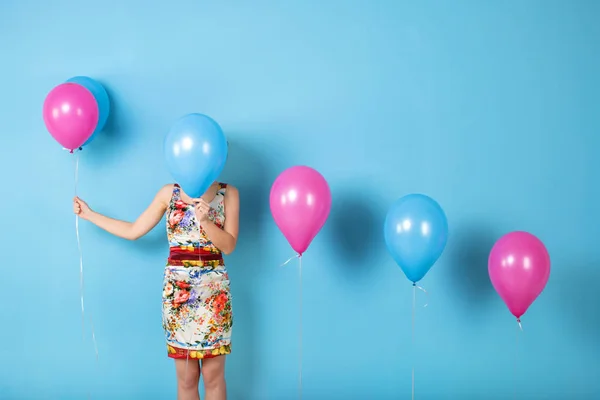 Mulher e hélio balões em um fundo azul . — Fotografia de Stock