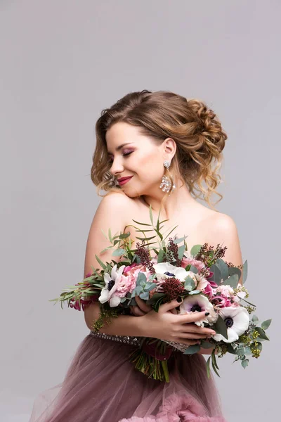 Bela mulher com um buquê de flores. — Fotografia de Stock