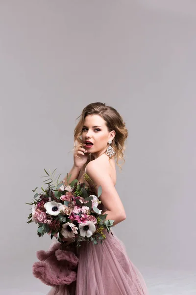 Penteado. Menina posando em vestido rosa comprimento total. Estúdio — Fotografia de Stock