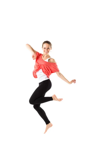 Cheerful, athletic girl jumping and looking into the camera. Isolated. — Stock Photo, Image
