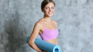 Genç güzel kız ile yoga mat gülümseyen.