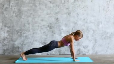 Uygun sportif kadının push-up yoga mat yapması.