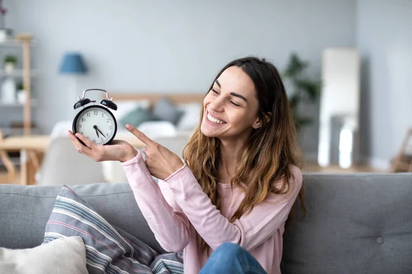 Feliz bela jovem mulher detém despertador . — Fotografia de Stock