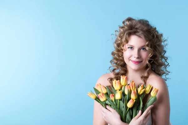 Portrait of a beautiful smiling caucasian woman with tulips in s — Stock Photo, Image