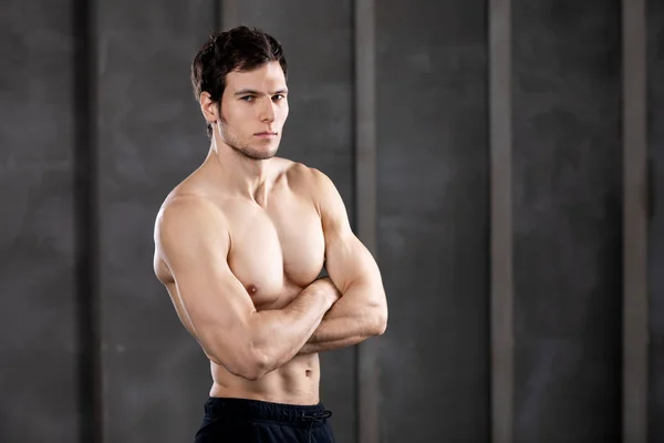 Muskelkräftiger junger Mann in einem Atelier. Porträt eines starken brutalen Typen. — Stockfoto