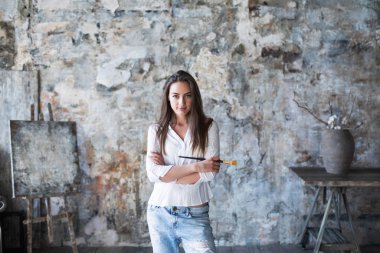 Stüdyoda genç bir kadın sanatçı. 