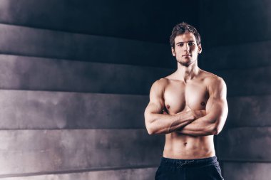 İri kaslı, güzel, güçlü genç bir adam. Telif alanı olan karanlık stüdyoda vücut geliştirici.