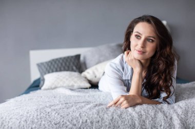 Evdeki yatakta gülümseyen güzel bir kadının portresi. İçerideki kız.