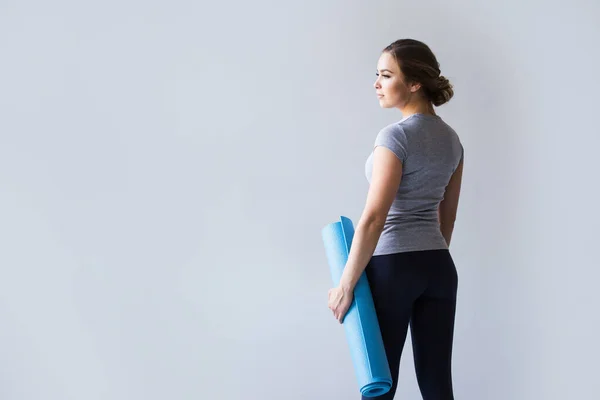 Mujer Deportiva Sosteniendo Estera Yoga Sobre Fondo Gris —  Fotos de Stock