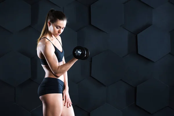 Atletische Vrouw Pompen Spieren Met Halters Een Donkere Achtergrond — Stockfoto