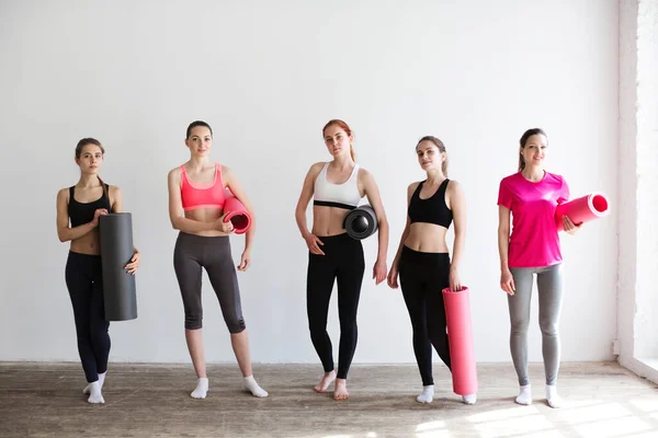 Beyaz Duvarda Yoga Minderleri Olan Bir Grup Genç Sporcu Kadın — Stok fotoğraf