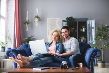 Evde dizüstü bilgisayarı olan mutlu bir aile. Birbirine aşık çift.
