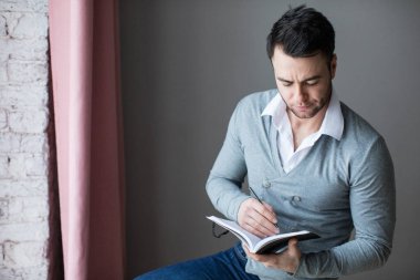 Yakışıklı defterine notlar alıyor. Öğrenci.