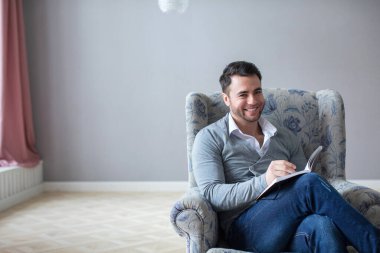 Elinde not defteri olan yakışıklı bir adam, bir psikolog ya da bir danışman. Aile psikologu.