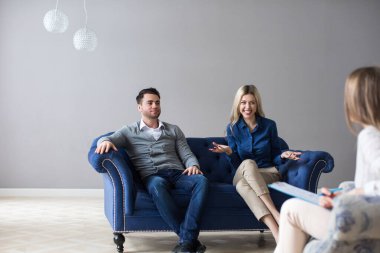 Aile sorunları için psikoloğu ziyaret eden mutlu genç çift. Sevgili eşler uzlaşmayı, evlilik danışmanlığı kavramını bulurlar..