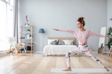 Yoga yapan genç bir Yogi kadın, evde çalışıyor. Yaşam tarzı ve kilo kaybı kavramı. 
