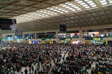 Wuhan, Çin 'deki kalabalık tren istasyonu. Tren istasyonunda büyük bir kalabalık bekliyor. Bagajı olan insanlar Çin 'de treni bekliyor.. 