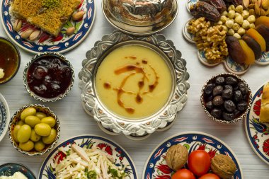 Traditional Turkish Ramadan,iftar meal table with lentil soup in vintage silver soup bowl on middle of table with other foods. clipart