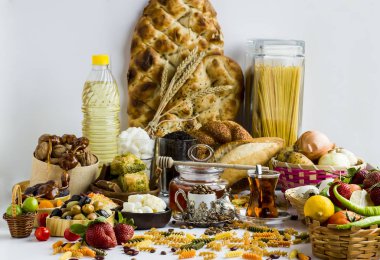 Ramazan, bal, sıvı yağ, ekmek (pide) çayı, şeker, kahve çekirdekleri, sebzeler, beyaz zeminde taze ve kuru besinler için alışveriş kavramı. Genel görünüm