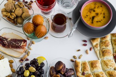 Ramazan 'ın sembolik gıdaları: ekmek, çorba, tatlı, ceviz, hurma meyveleri, kuru yaş eti, kırmızı gül şerbeti, zeytin, çay ve fotokopi alanı olan beyaz üzerine bir bardak su