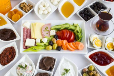 Geleneksel, taze ve renkli Türk kahvaltısı, beyaz ve şık porselen tabaklarla beyaz masada Türk çayı ve taze portakal suyu ile servis edilir..