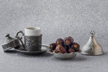 Geleneksel Arap Acı Kahvesi ve parlak gümüş arka planda kurutulmuş meyveler. Ramazan kavramı.