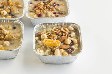 Geleneksel Tatlı Emin, alüminyum kaselerde Nuh Pudingi - beyaz yüzeyde paket götür.