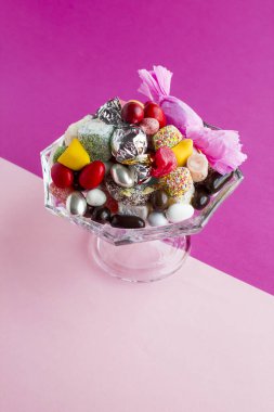 close-up shot of delicious various candies in cup on white surface
