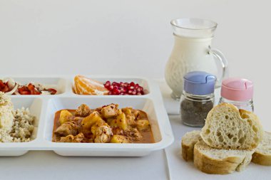 Yemek tepsisindeki (masa başı) çeşitli lezzetli yiyeceklerin beyaz üzerine yakın plan çekimi