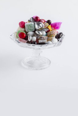 close-up shot of delicious various candies in cup on white surface