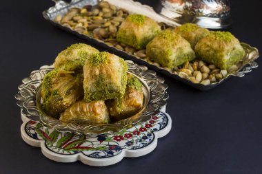 Geleneksel Türk tatlı baklavası, siyah kapta metal tepsiyle..