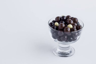 close-up shot of delicious chocolate candies in glass cups on white