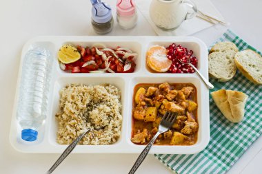 Yemek tepsisindeki (masa başı) çeşitli lezzetli yiyeceklerin beyaz üzerine yakın plan çekimi