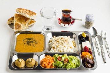 Yemek tepsisindeki (masa başı) çeşitli lezzetli yiyeceklerin beyaz üzerine yakın plan çekimi