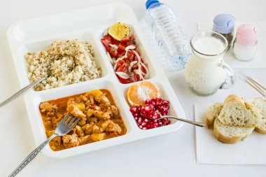 Yemek tepsisindeki (masa başı) çeşitli lezzetli yiyeceklerin beyaz üzerine yakın plan çekimi