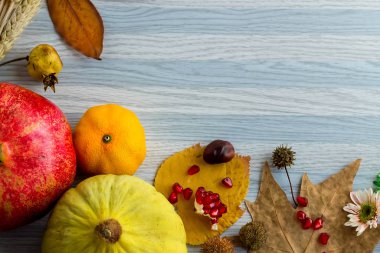 Düşen yaprakların yakın plan çekimi ve sonbahar kompozisyon arka planı için ahşap masa üstünde çeşitli mevsimlik hasat.