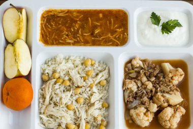 Yemek tepsisindeki (masa başı) çeşitli lezzetli yiyeceklerin beyaz üzerine yakın plan çekimi