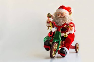 Beyaz yüzeyde bisikletli Noel Baba figürü