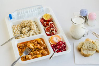 Yemek tepsisindeki (masa başı) çeşitli lezzetli yiyeceklerin beyaz üzerine yakın plan çekimi