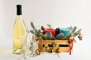 Yeni yıl arifesi ve iki bardak şampanya ve beyaz arka planda Noel dekoruyla dolu ahşap bir kutu ile kutlama konsepti