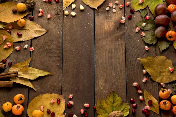 Düşen yaprakların yakın plan çekimi ve sonbahar kompozisyon arka planı için ahşap masa üstünde çeşitli mevsimlik hasat.