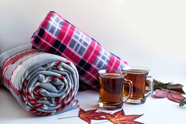 close-up shot of fleece plaid scarves with cups of tea on white surface